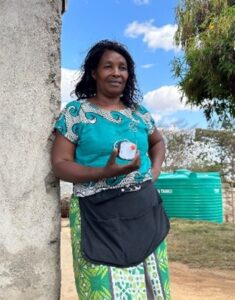 Ann Wangari posing with a solar light that she financed from VEP.